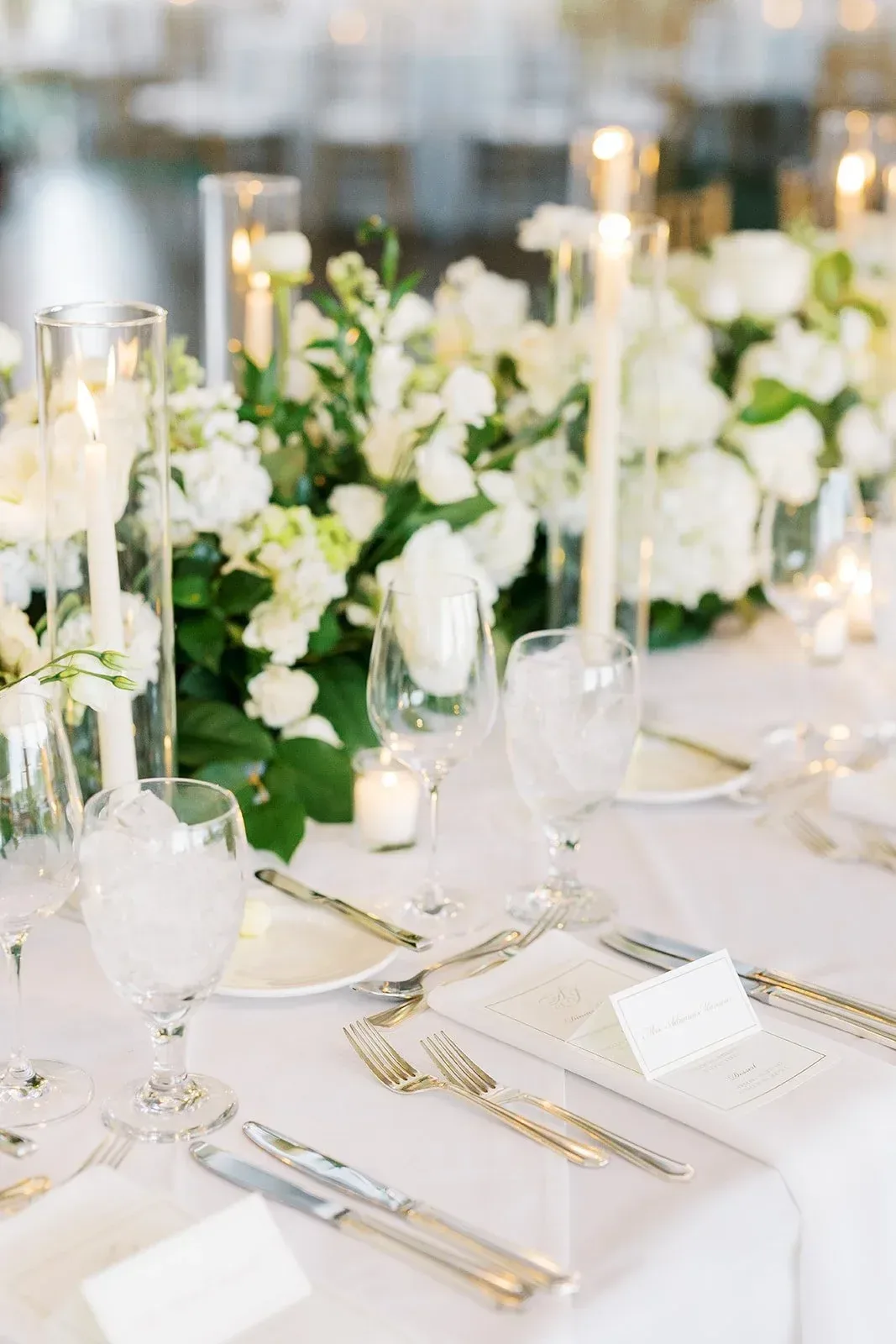 Place cards and menus on a white and green reception table