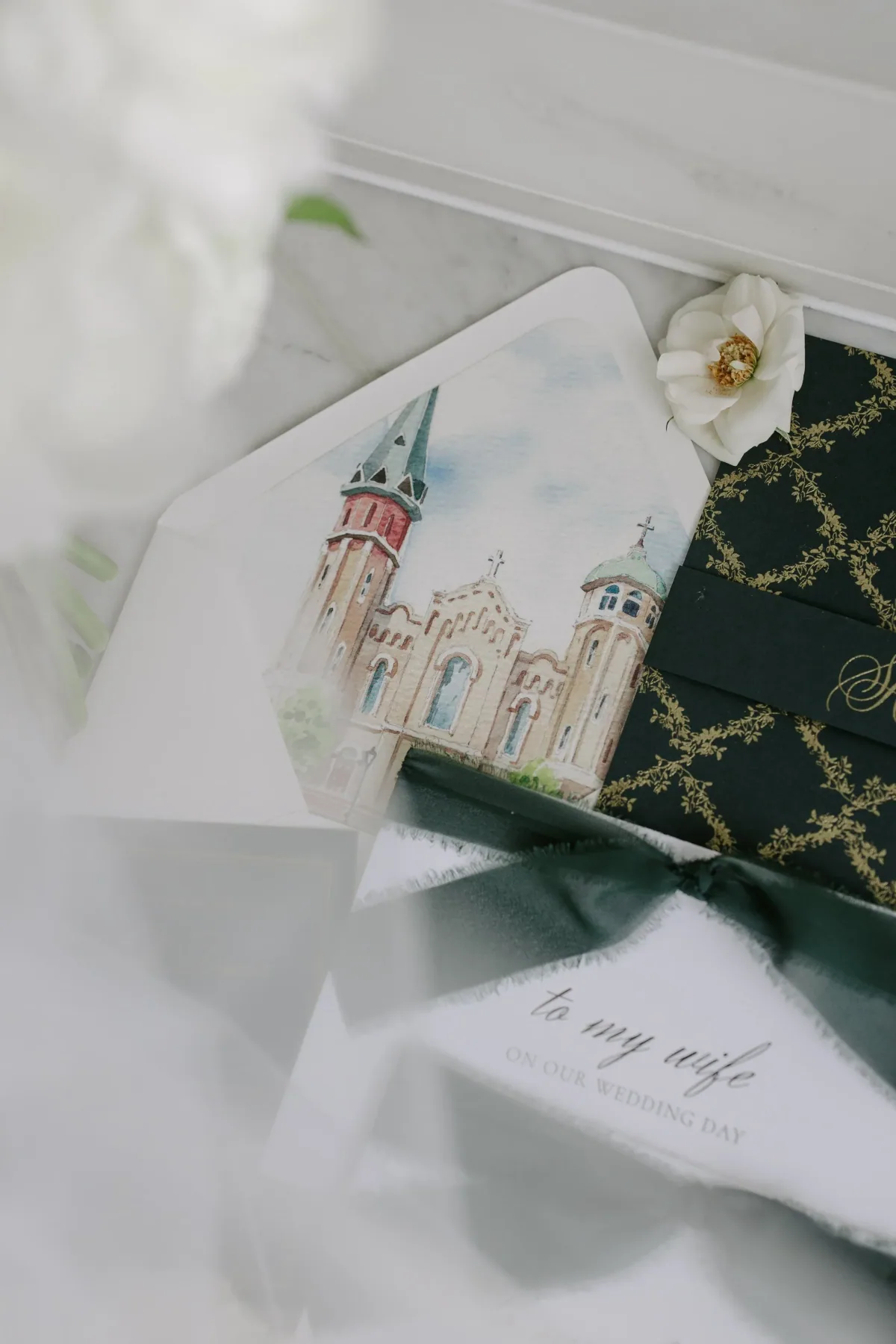 Envelope liner illustrated with a church, beside a black and gold patterned card