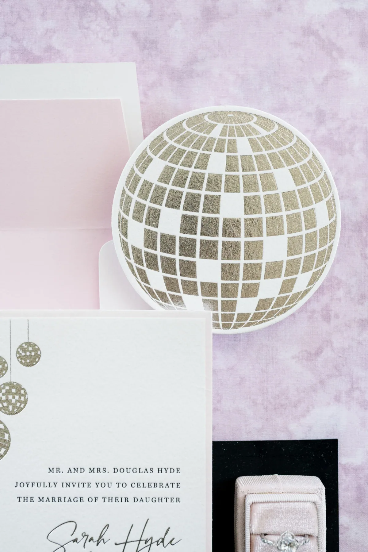 Wedding invitation with a disco ball motif, styled with a mirrored disco ball