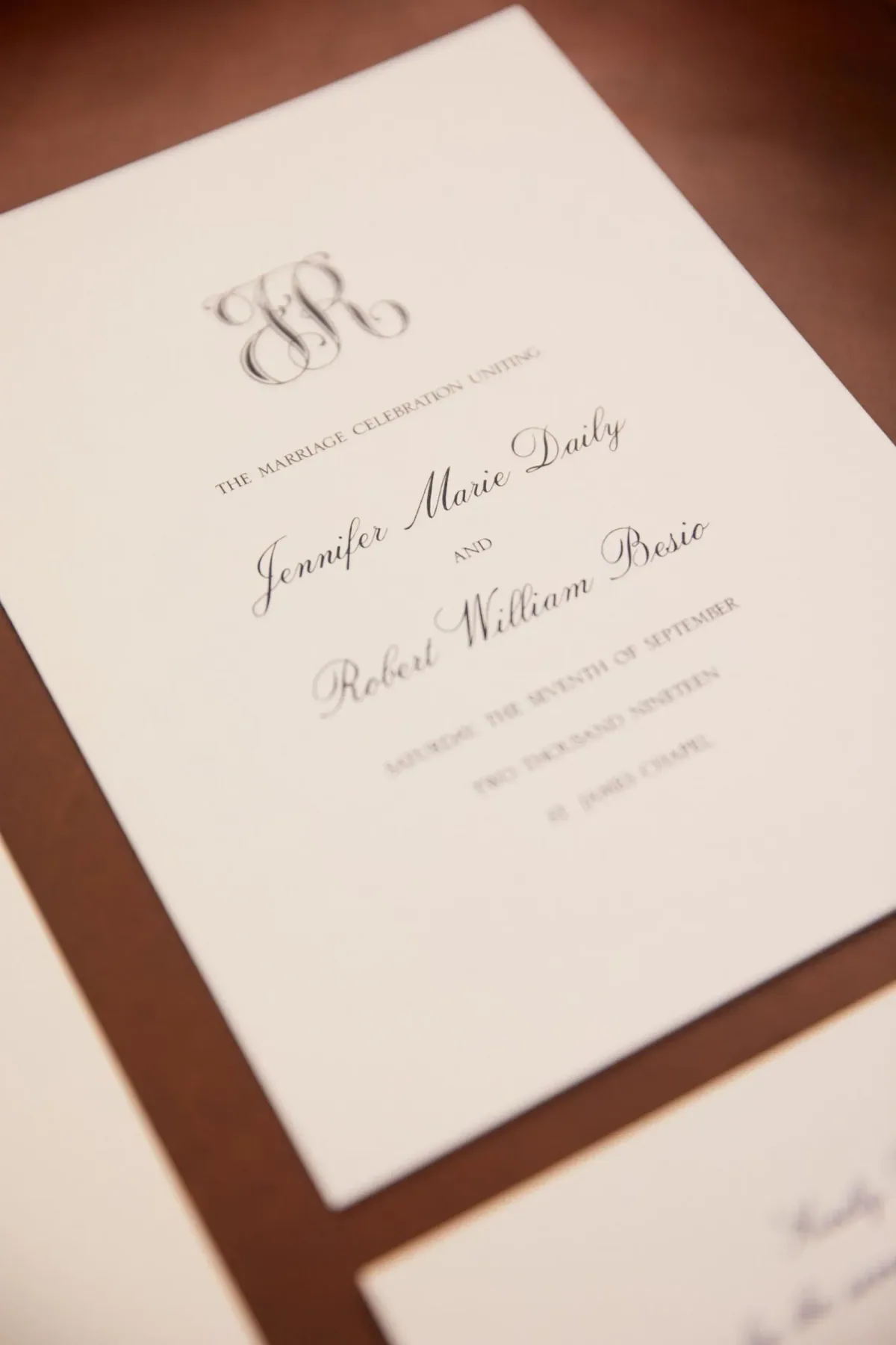 Ceremony program with script monogram on a brown backing