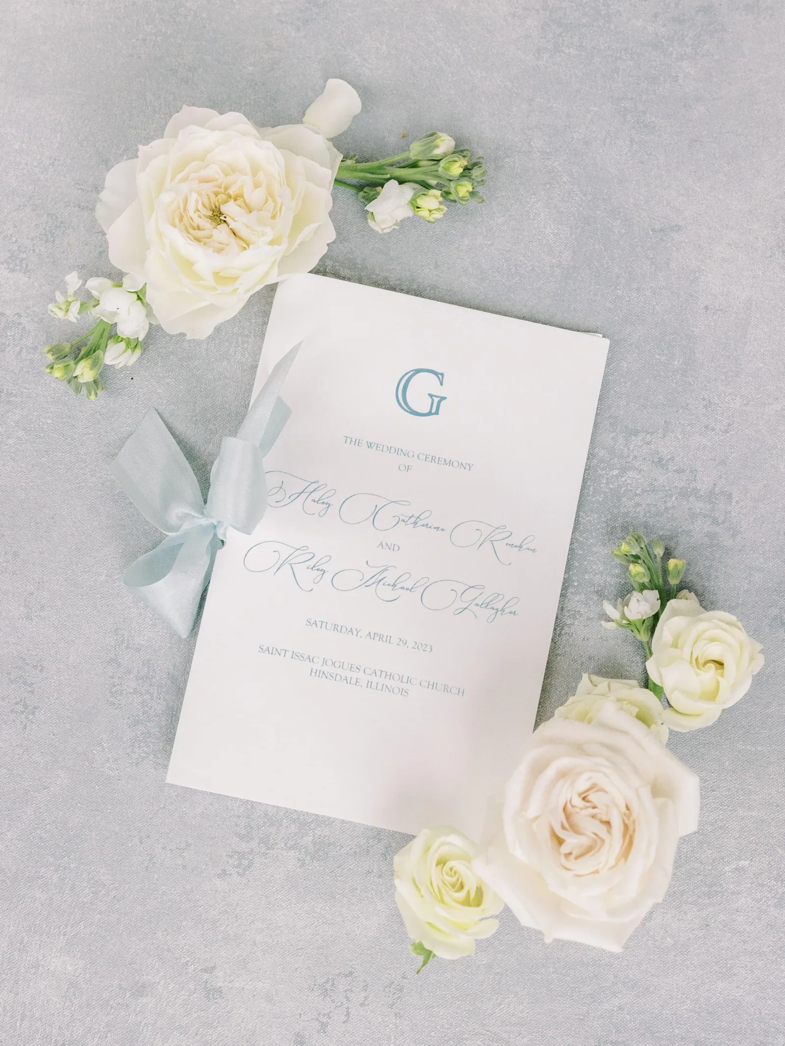 Close detail — Ceremony program with white florals